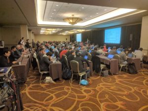Attendees at the OpenStack Summit in Boston, discussing the future of networking