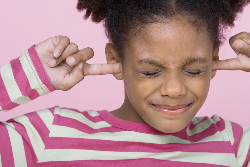 Port collisions: A child plugging their ears, overwhelmed by too many pods trying to use the same port on a Kubernetes node