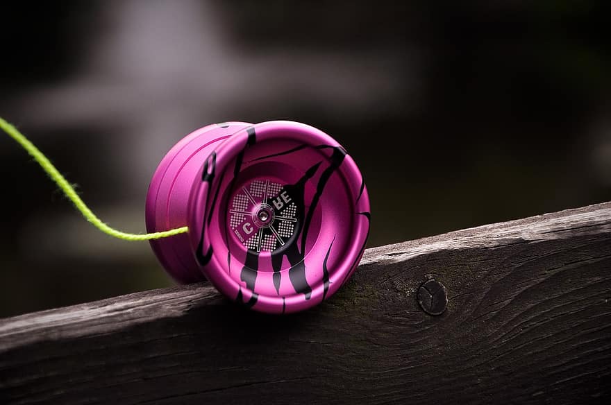 A pink yo-yo, resting on wood, illustrating the unpredictable nature of yo-yo attacks in a Kubernetes application