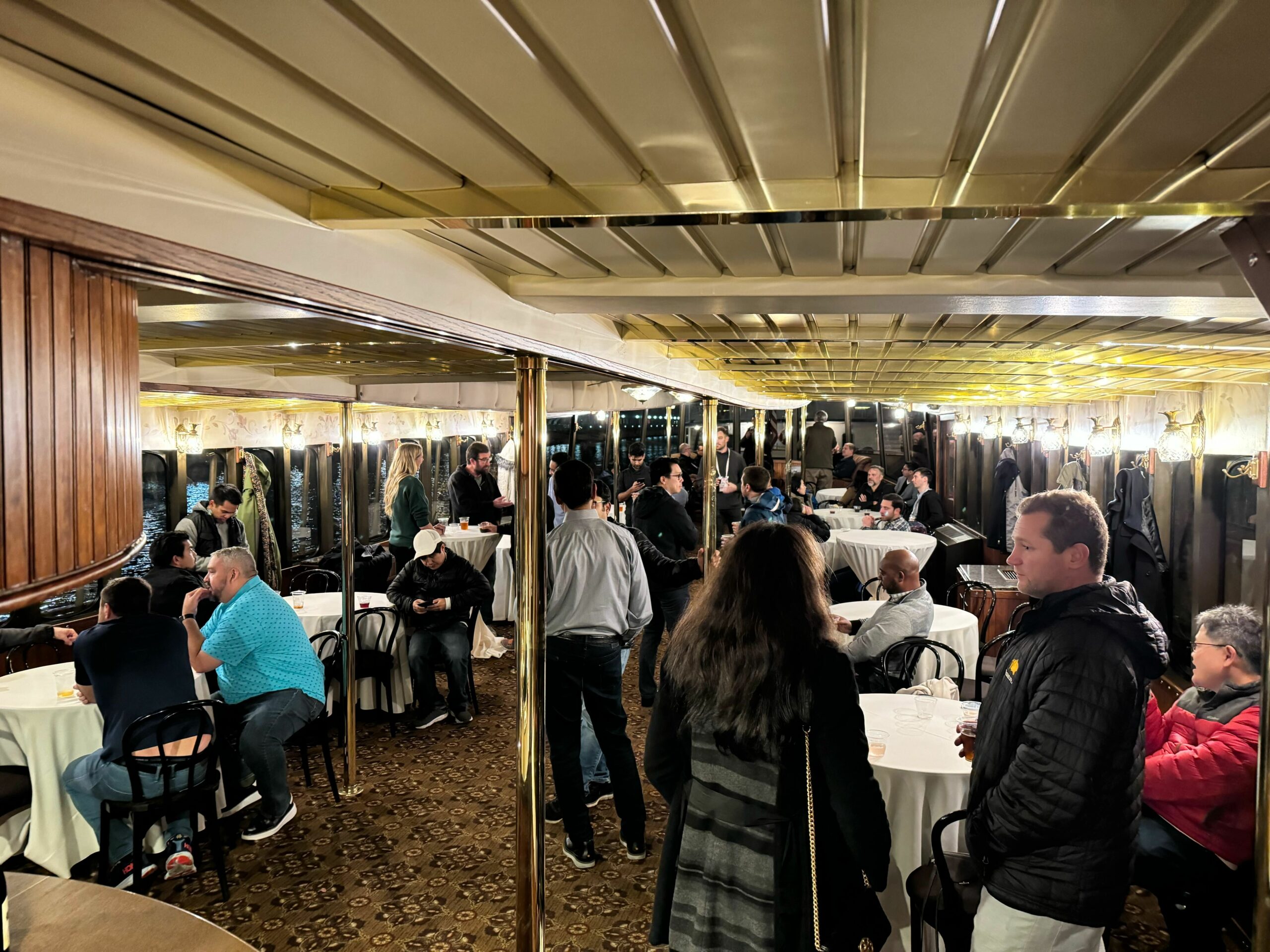 Attendees networking at the Tigera KubeCon NA 2023 cruise event on a lakefront boat