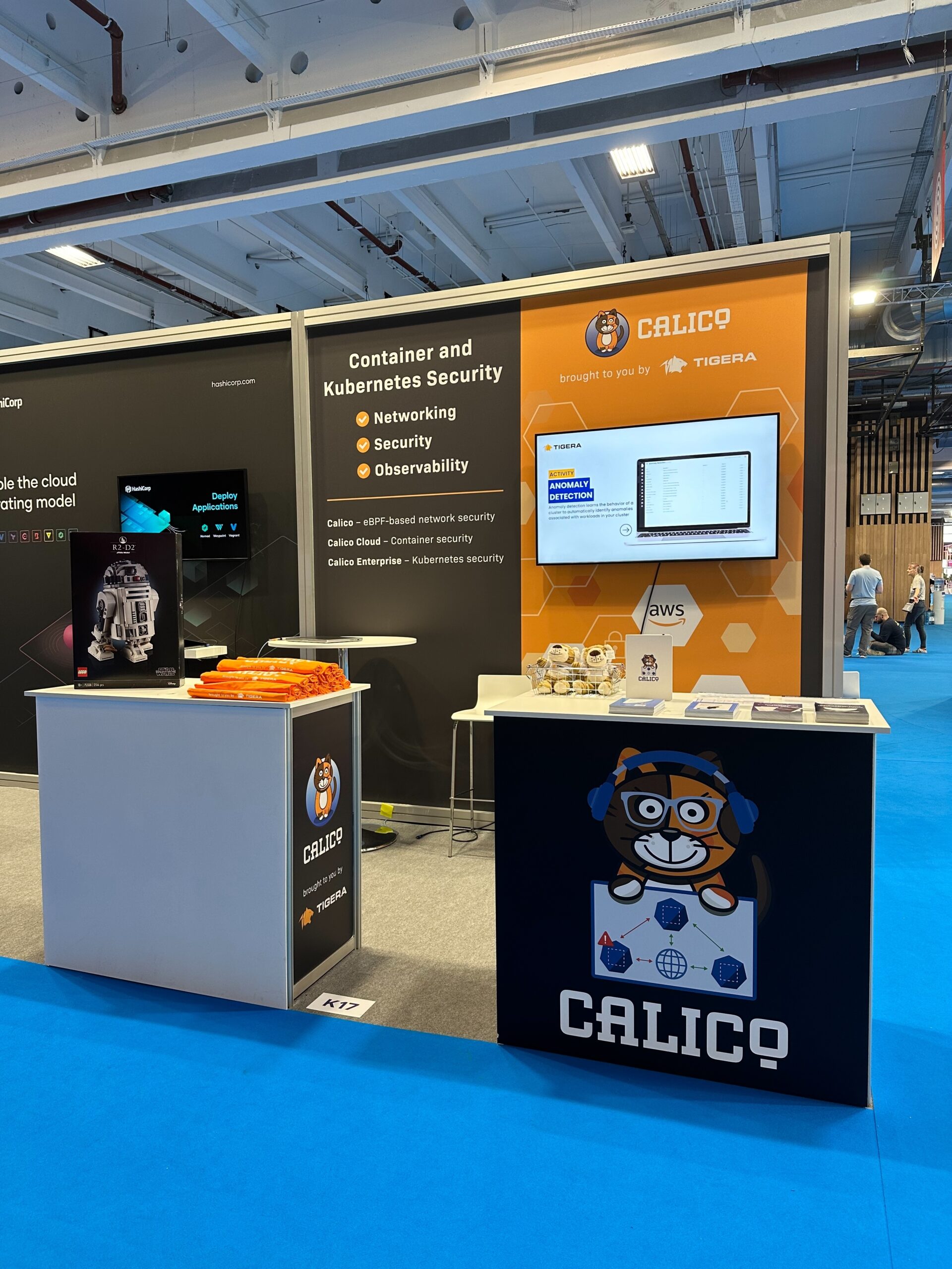 A Calico and Tigera booth at a trade show. The booth features signage, displays, and Calico items