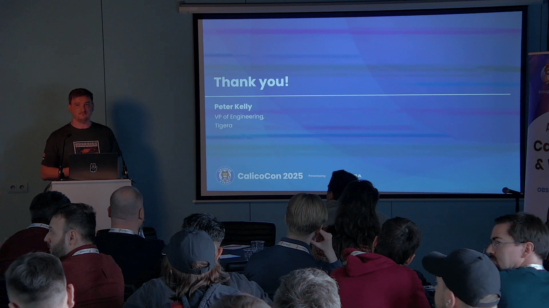 Peter Kelly presents at CalicoCon 2025, with his name and title on the screen.