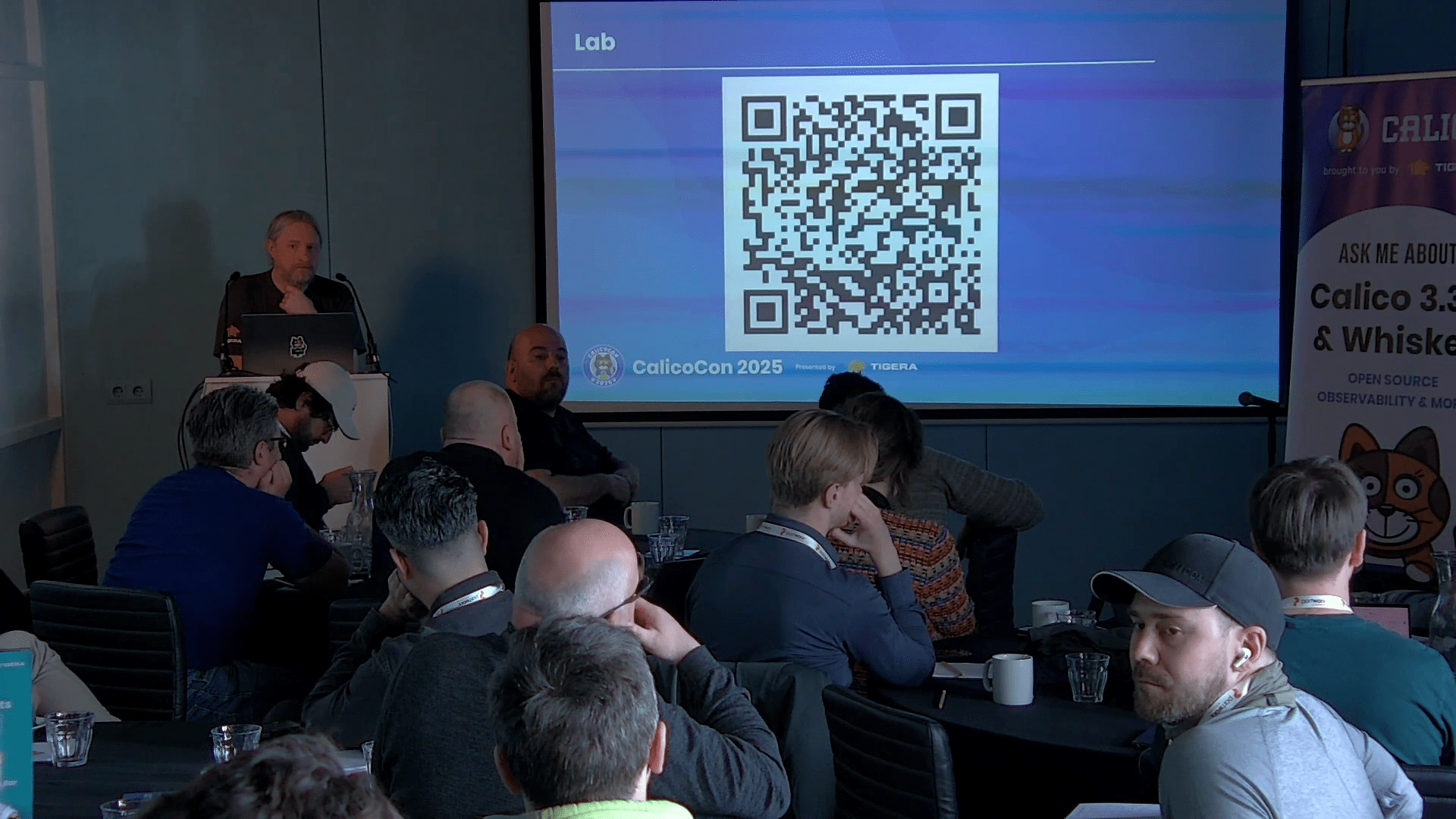 A speaker presents to an audience at a CalicoCon conference.