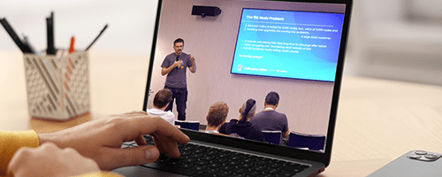 Hands type on a laptop displaying a live presentation.